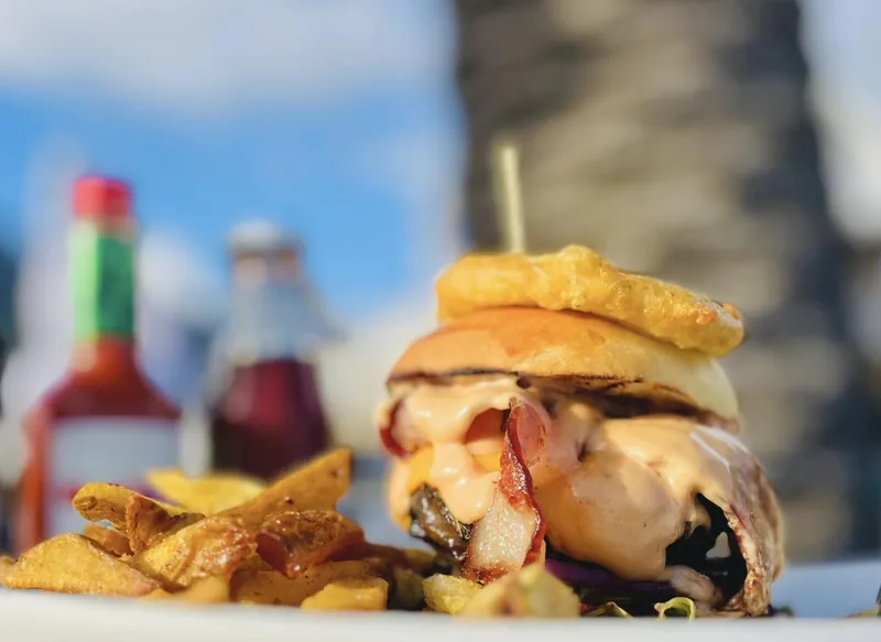 A Dunes Deluxe burger with bacon, cheese and chips, in the sun