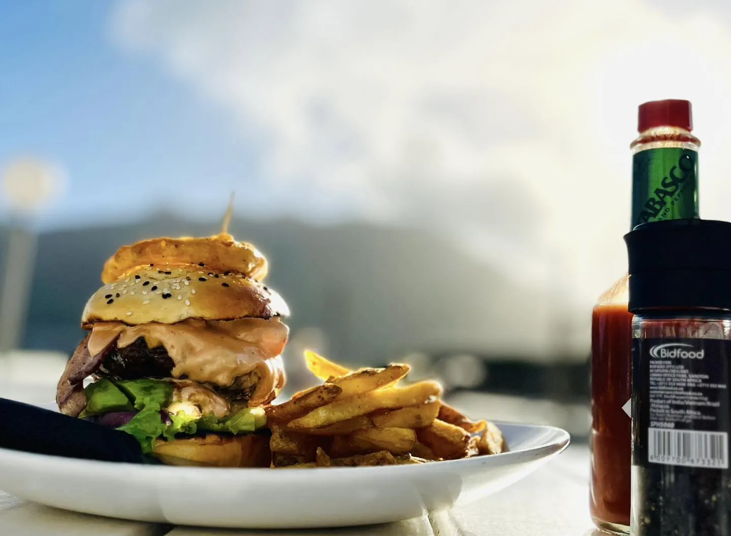 A Dunes burger and chips in the sun, with the mountains behind