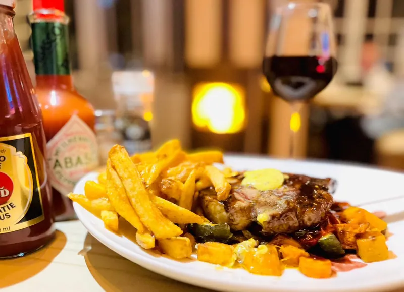 Sirloin with herb butter, roasted vegetables and home-made chips, by candlelight with a glass of red